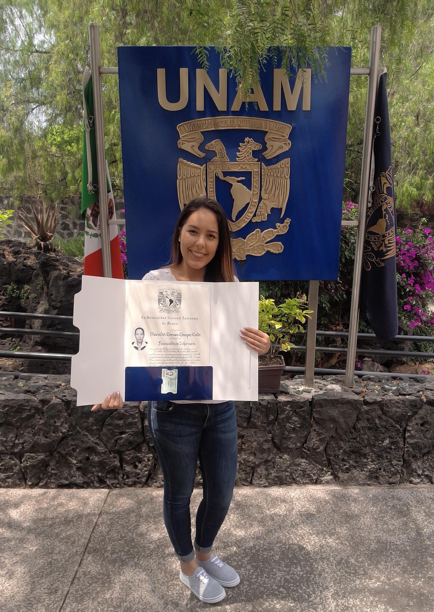 Alumna sosteniendo su título de UNAM